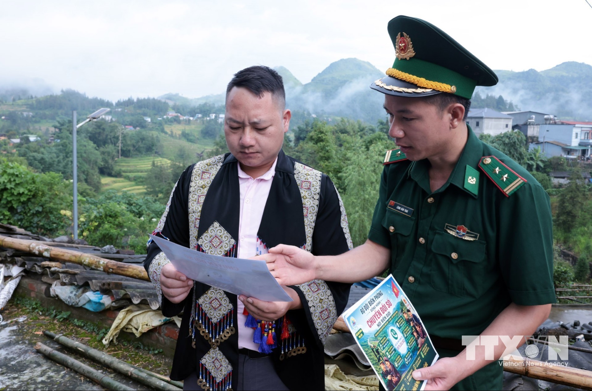 Cán bộ Biên phòng Pha Lon đến tận thôn, bản phát tờ rơi và tuyên truyền pháp luật và tiếp cận nền tảng số. (Ảnh: Trần Việt/TTXVN)